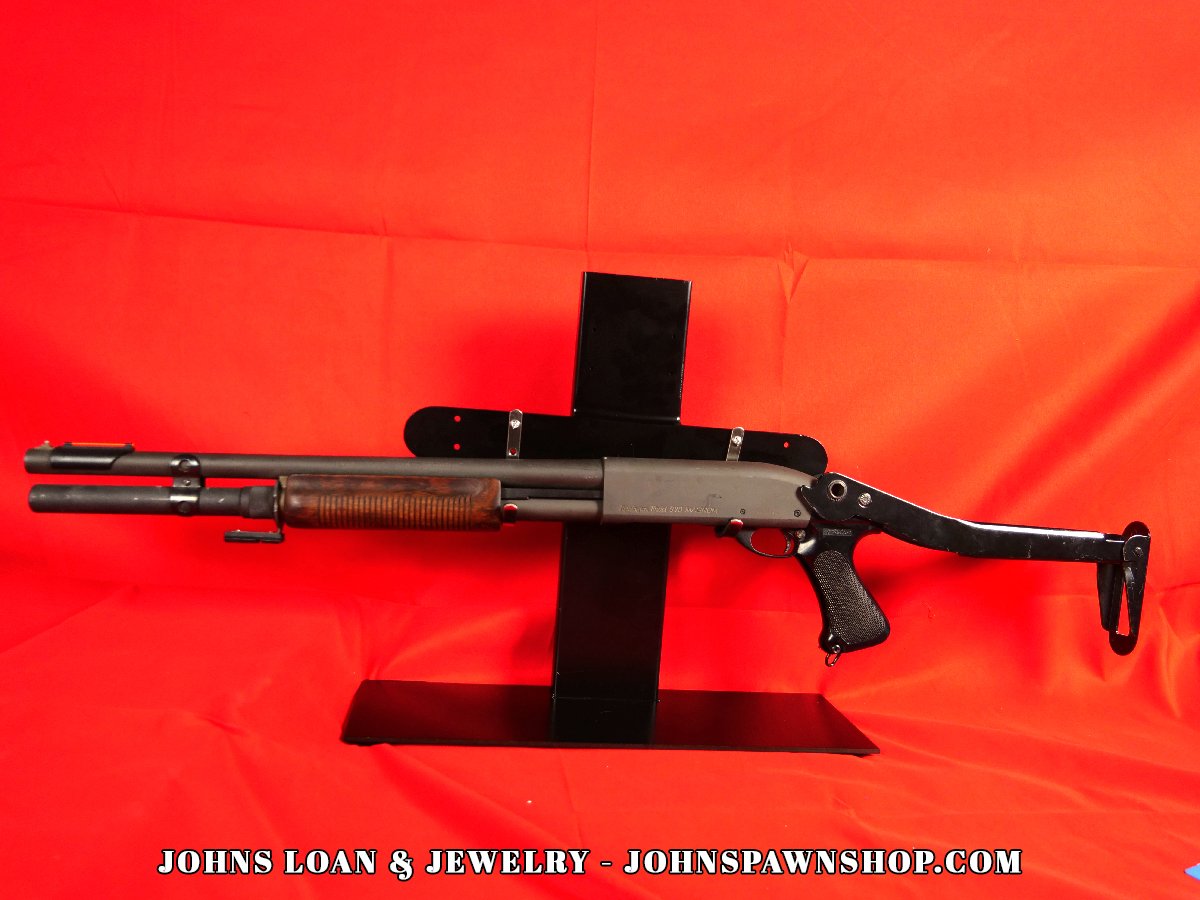 Remington 870 Magnum shotgun with folding stock, showcasing the police enforcement firearm's profile at John's Loan & Jewelry, a Las Vegas pawn shop.