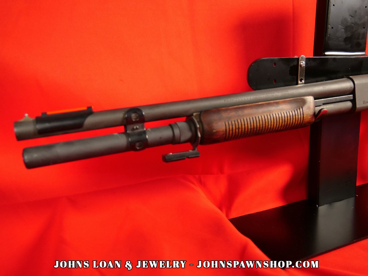 Detailed view of the Remington 870 Magnum police shotgun's barrel and wood forend, highlighting the firearm's design at John's Loan & Jewelry.
