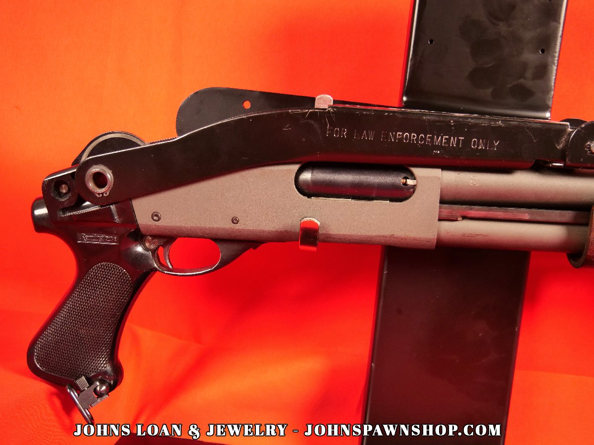 Close-up of the Remington 870 Magnum Police shotgun receiver, marked "For Law Enforcement Only", and the folding stock, available from John's Loan & Jewelry.