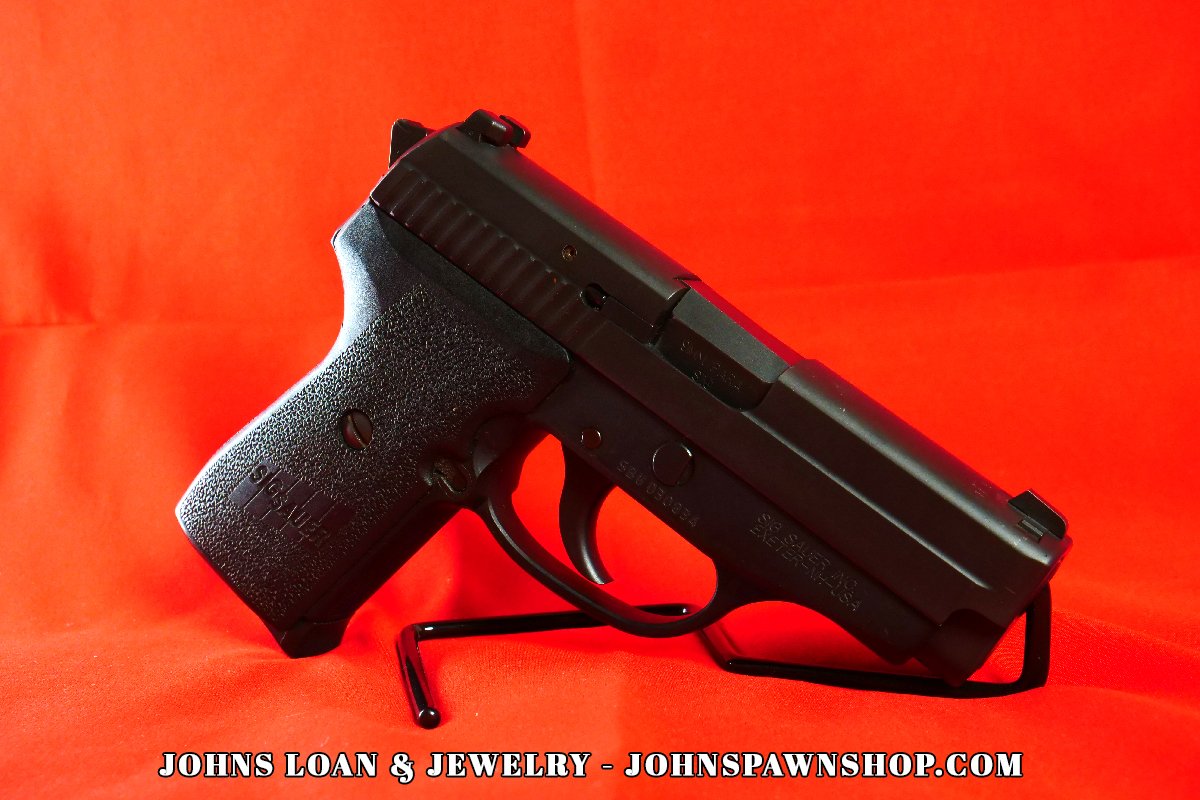 Angled shot of a Sig Sauer P239 9mm semi auto pistol, showing the grip texture and slide details; find this firearm at John's Loan & Jewelry pawn shop.