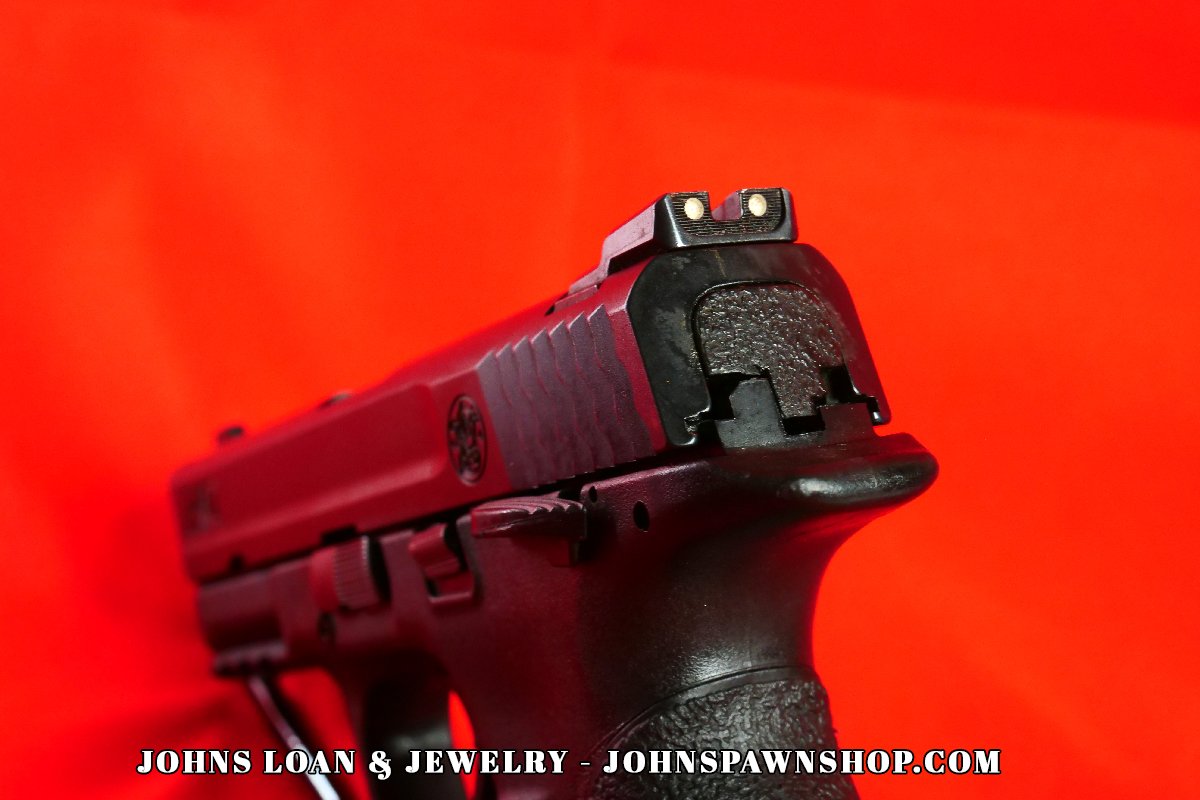 Rear view of the Smith & Wesson Military & Police 9mm pistol, focusing on the serrated slide and rear sight, offered by John's Loan & Jewelry.