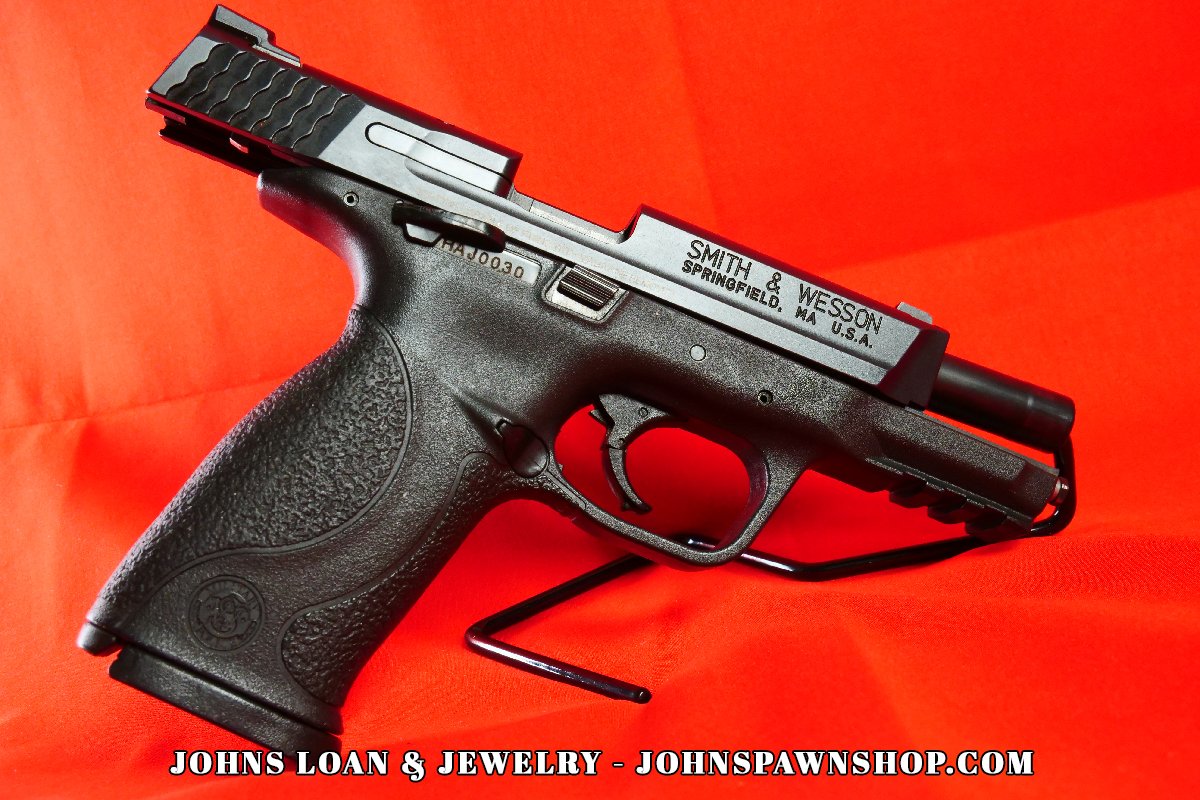 Smith & Wesson Military & Police 9mm semi-auto pistol on display at John's Loan & Jewelry, featuring the polymer grip and matte black finish in excellent shape.